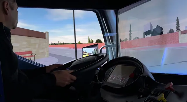 Conductor al volante de la cabina de camión del simulador durante un ejercicio de maniobras